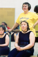 Coach and two athletes watch performance.